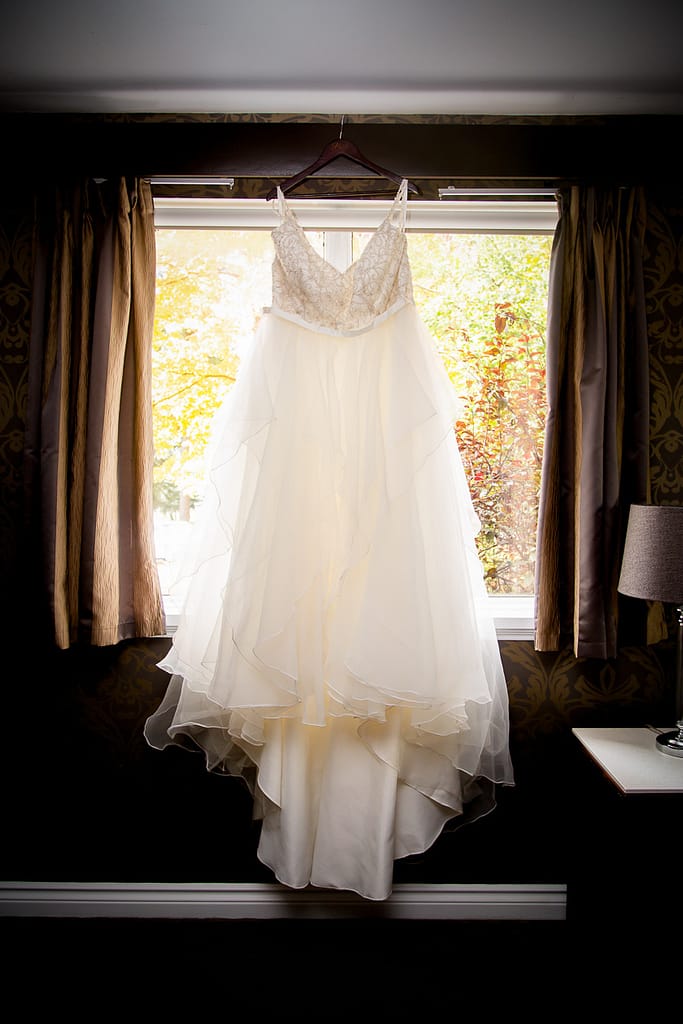 dress hanging in window at Elm Hurst wedding photography by london ontario photographer Woodgate Photography